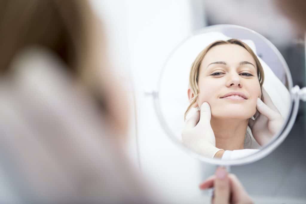Aesthetic surgery, woman looking in mirror